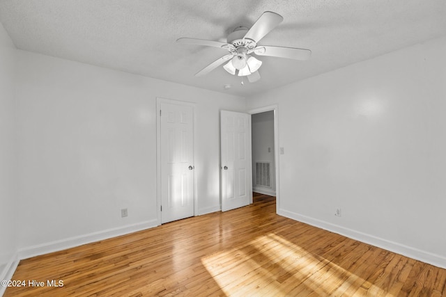 spare room featuring wood-type flooring, a textured ceiling, and ceiling fan