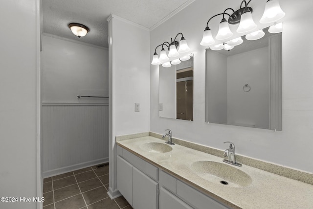 bathroom with tile patterned flooring, vanity, a textured ceiling, and ornamental molding