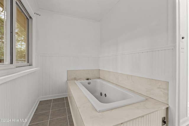 bathroom featuring tile patterned flooring, crown molding, and a tub