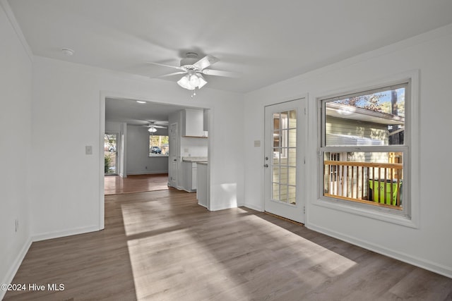 interior space with hardwood / wood-style floors, ceiling fan, and crown molding