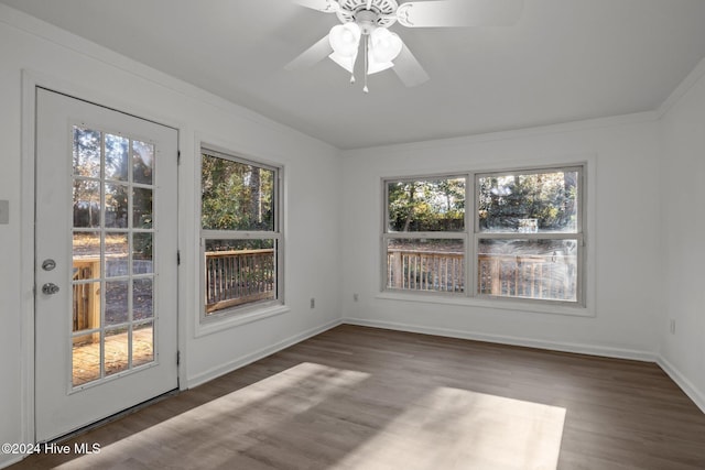 unfurnished dining area featuring ceiling fan, ornamental molding, and dark wood-type flooring