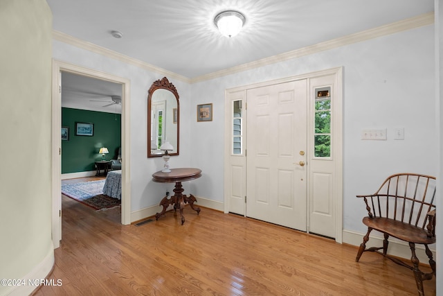 foyer with crown molding, ceiling fan, and light hardwood / wood-style floors