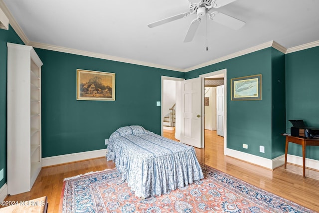 bedroom with crown molding, light hardwood / wood-style flooring, and ceiling fan