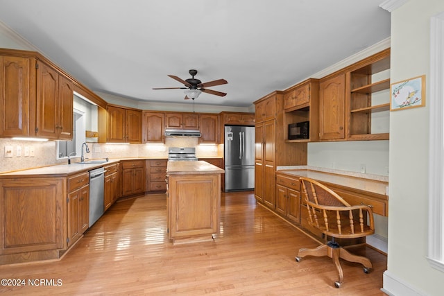 kitchen with stainless steel appliances, sink, a center island, and light wood-type flooring