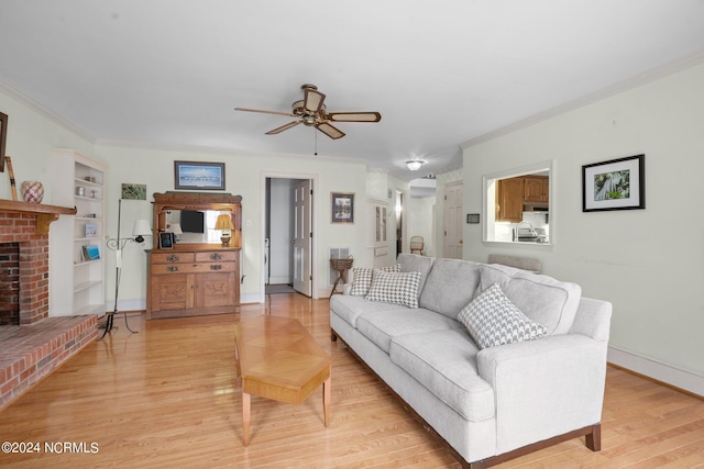 living room with built in shelves, a brick fireplace, light wood-type flooring, and ceiling fan