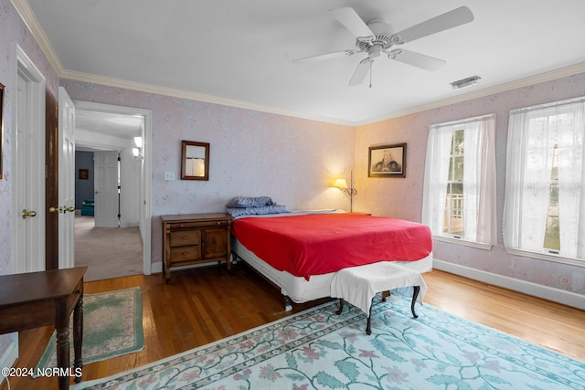 bedroom with crown molding, ceiling fan, and hardwood / wood-style floors