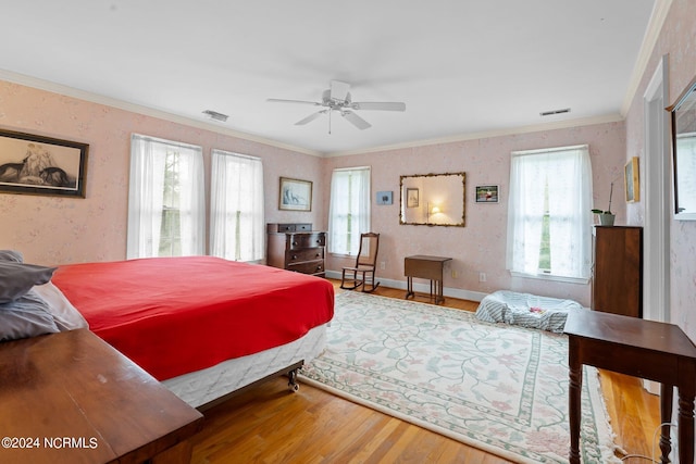 bedroom featuring hardwood / wood-style flooring, crown molding, and ceiling fan