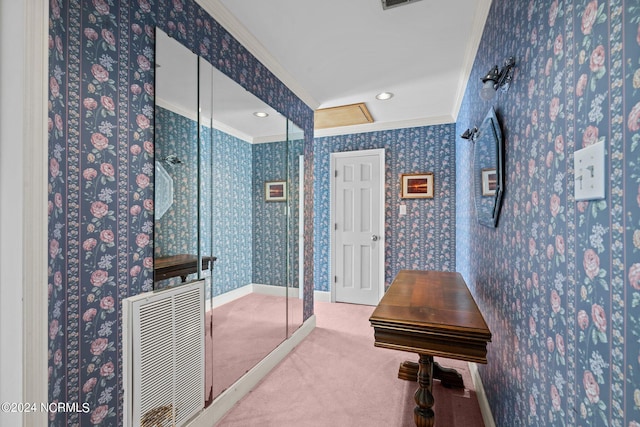 bathroom with a shower with door and crown molding