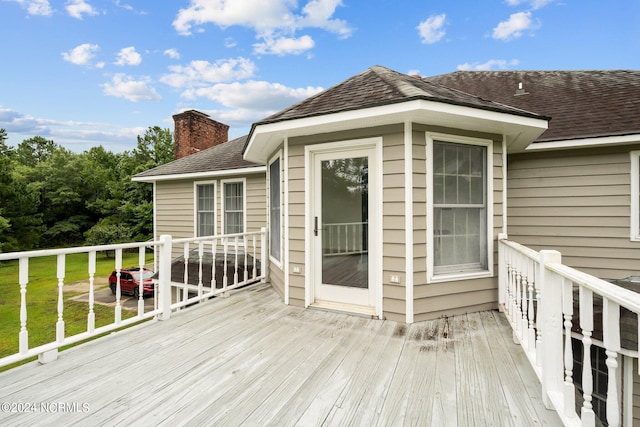 wooden terrace featuring a lawn