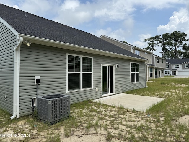 back of property with a patio, a lawn, and central AC unit