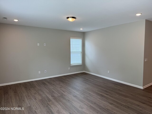 spare room featuring dark wood-type flooring