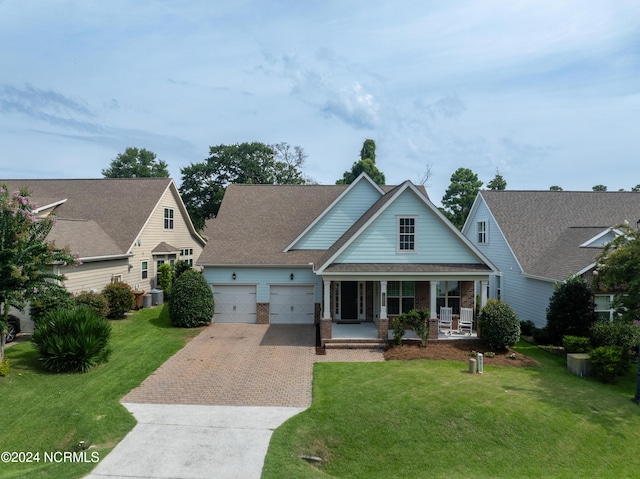 view of front facade with a porch, a garage, a front yard, and cooling unit