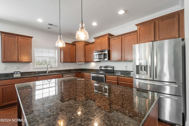 kitchen featuring a kitchen island, appliances with stainless steel finishes, sink, hanging light fixtures, and ornamental molding