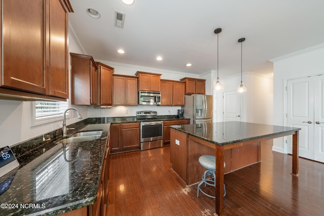 kitchen featuring a breakfast bar, pendant lighting, sink, a center island, and stainless steel appliances