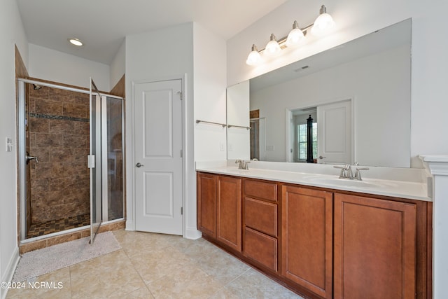 bathroom featuring a shower with door, vanity, and tile patterned floors