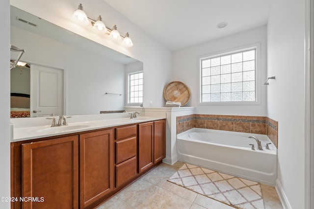 bathroom featuring tile patterned floors, a bathing tub, and vanity