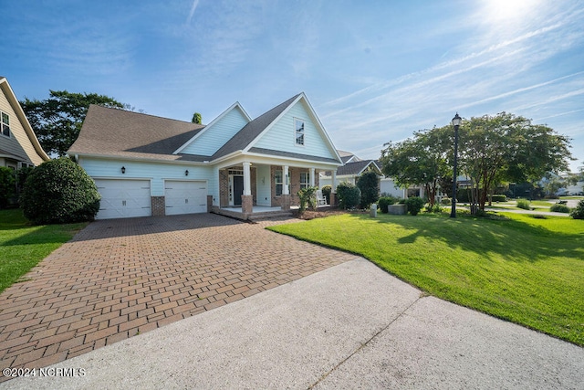 view of front of home featuring a garage, covered porch, and a front lawn