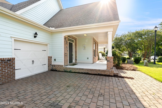 view of patio / terrace with a garage and covered porch