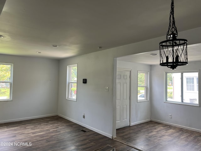 foyer entrance featuring dark wood-type flooring, a healthy amount of sunlight, and baseboards