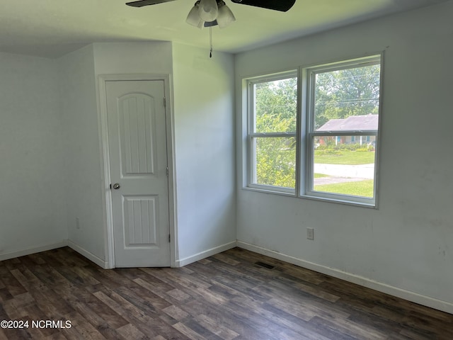 spare room with baseboards, visible vents, and dark wood finished floors