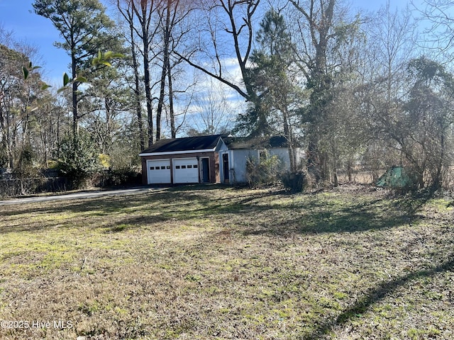 view of yard with an attached garage and fence