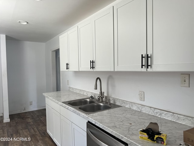 kitchen featuring dark wood-style flooring, stainless steel dishwasher, white cabinets, a sink, and baseboards