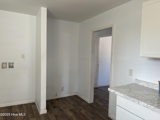 kitchen with white cabinets, baseboards, light countertops, and dark wood-style flooring