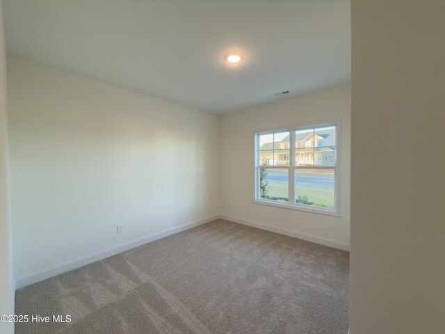 carpeted spare room featuring a raised ceiling and ceiling fan