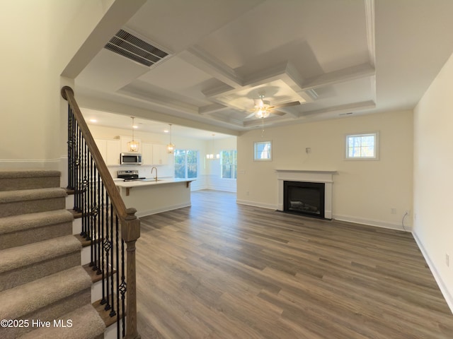 unfurnished living room with coffered ceiling, dark wood-type flooring, sink, and ceiling fan