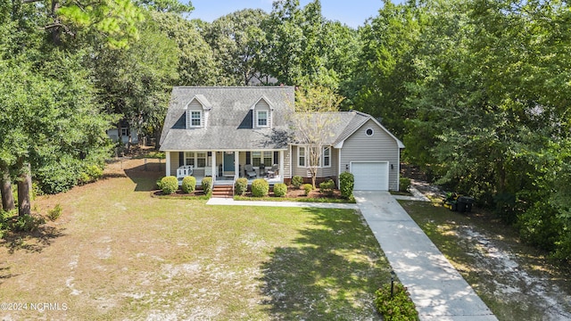 cape cod house featuring a porch, a garage, an outbuilding, and a front lawn