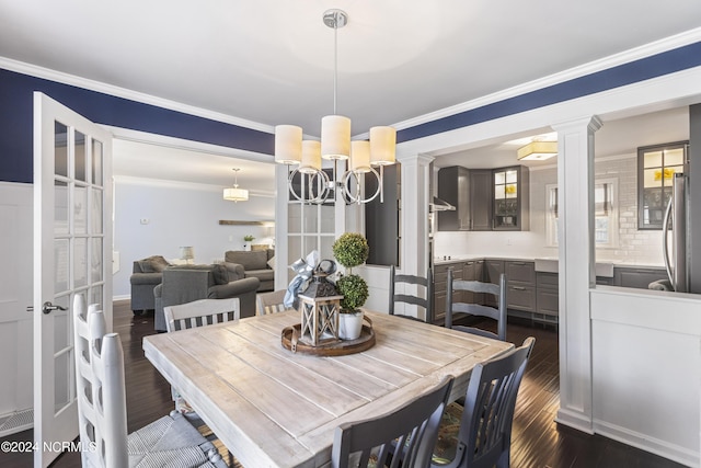 dining room featuring crown molding, dark hardwood / wood-style flooring, and an inviting chandelier