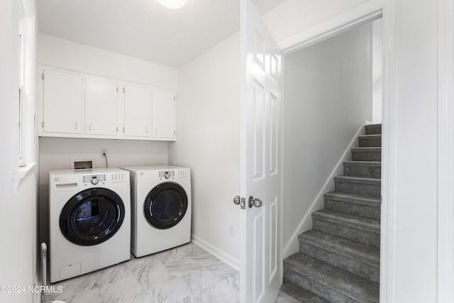 washroom with cabinets and washer and clothes dryer