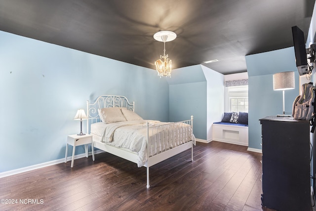 bedroom with dark hardwood / wood-style flooring and a chandelier