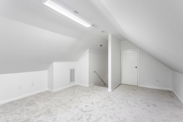 bonus room with light carpet and vaulted ceiling