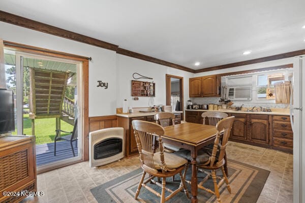 dining area featuring ornamental molding, sink, and light tile patterned floors