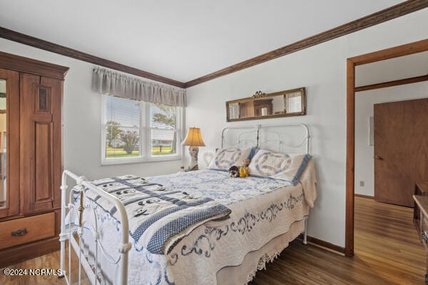 bedroom featuring crown molding and dark hardwood / wood-style flooring