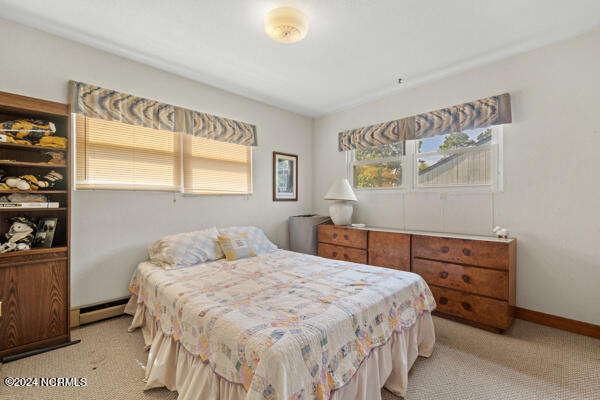 carpeted bedroom featuring a baseboard heating unit