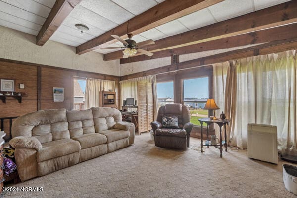 living room featuring wood walls, ceiling fan, carpet flooring, and beam ceiling