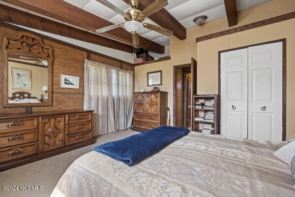 bedroom with a closet, carpet flooring, beam ceiling, and ceiling fan