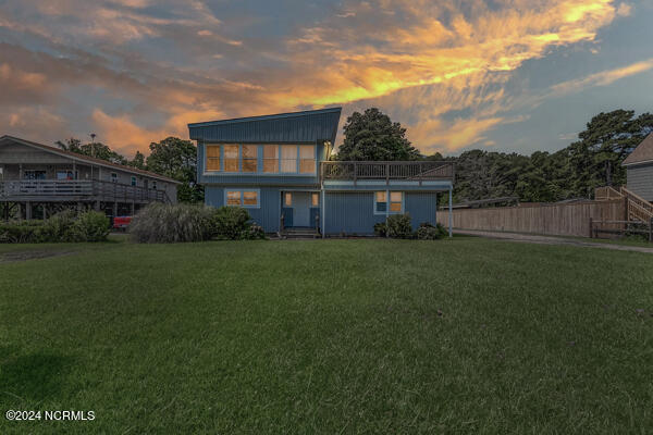 back house at dusk with a lawn