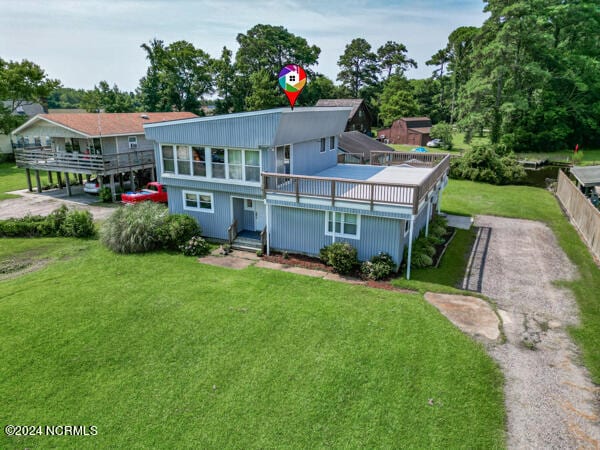 rear view of property featuring a lawn