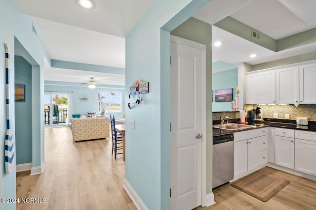 kitchen featuring white cabinetry, light hardwood / wood-style flooring, ceiling fan, decorative backsplash, and stainless steel dishwasher