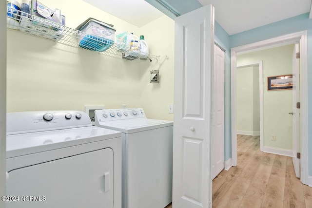 laundry room featuring light wood-type flooring and washer and dryer