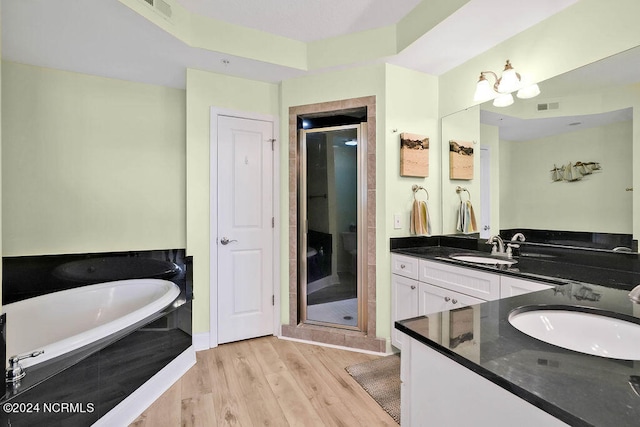 bathroom featuring plus walk in shower, hardwood / wood-style floors, and vanity