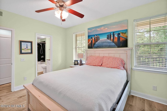 bedroom with light wood-type flooring, connected bathroom, ceiling fan, a closet, and a spacious closet