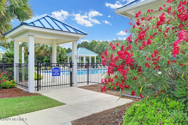 view of property's community featuring a swimming pool, a patio, and a gazebo