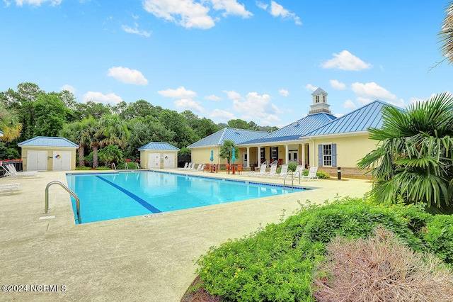 view of pool with a storage unit and a patio area