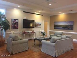 living room featuring ceiling fan and hardwood / wood-style flooring