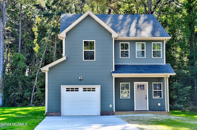 view of front of property featuring a front yard and a garage