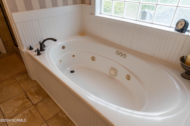 bathroom with a whirlpool tub, wainscoting, and tile patterned flooring